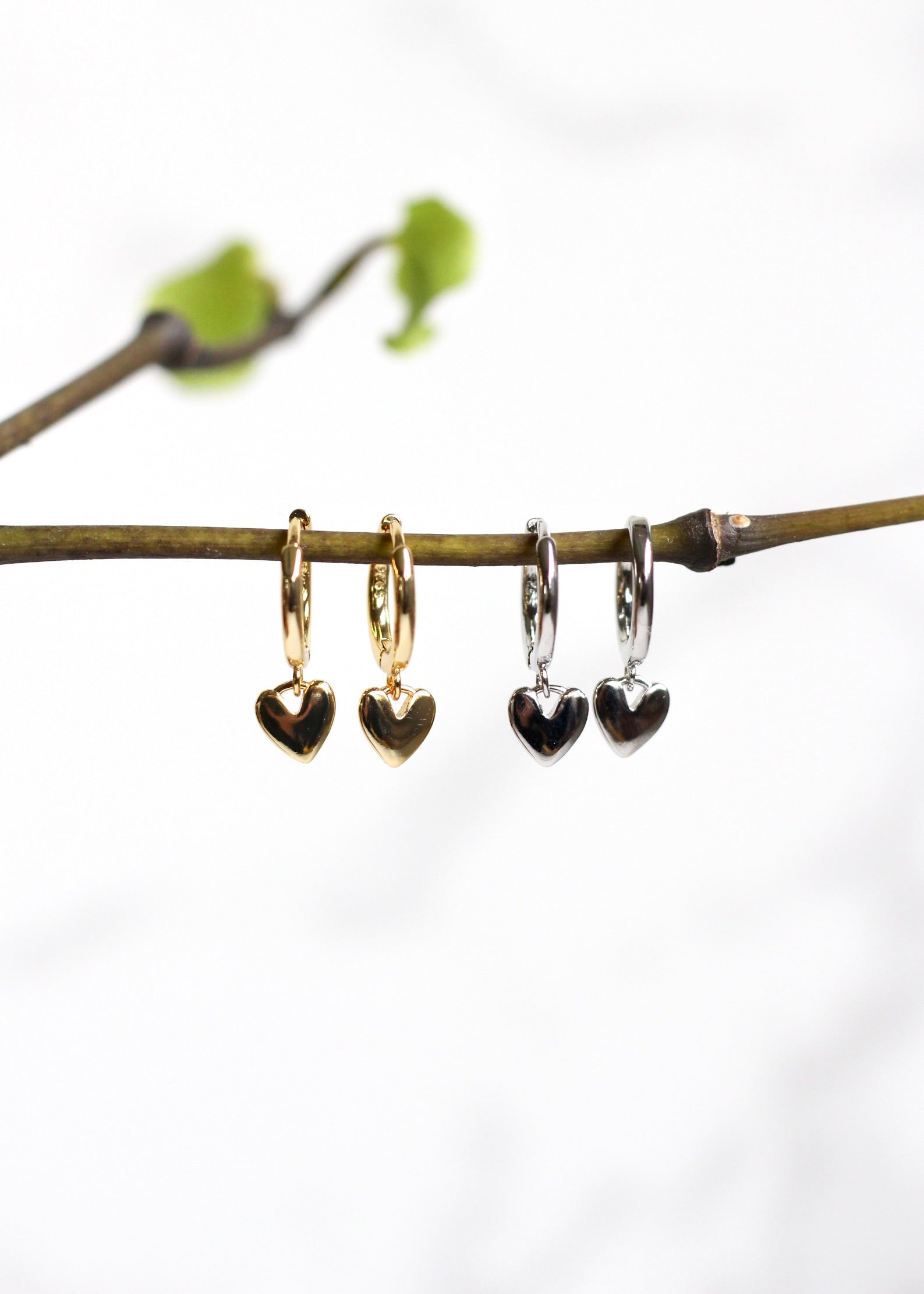 dainty huggie earrings with a heart dangling from the bottom